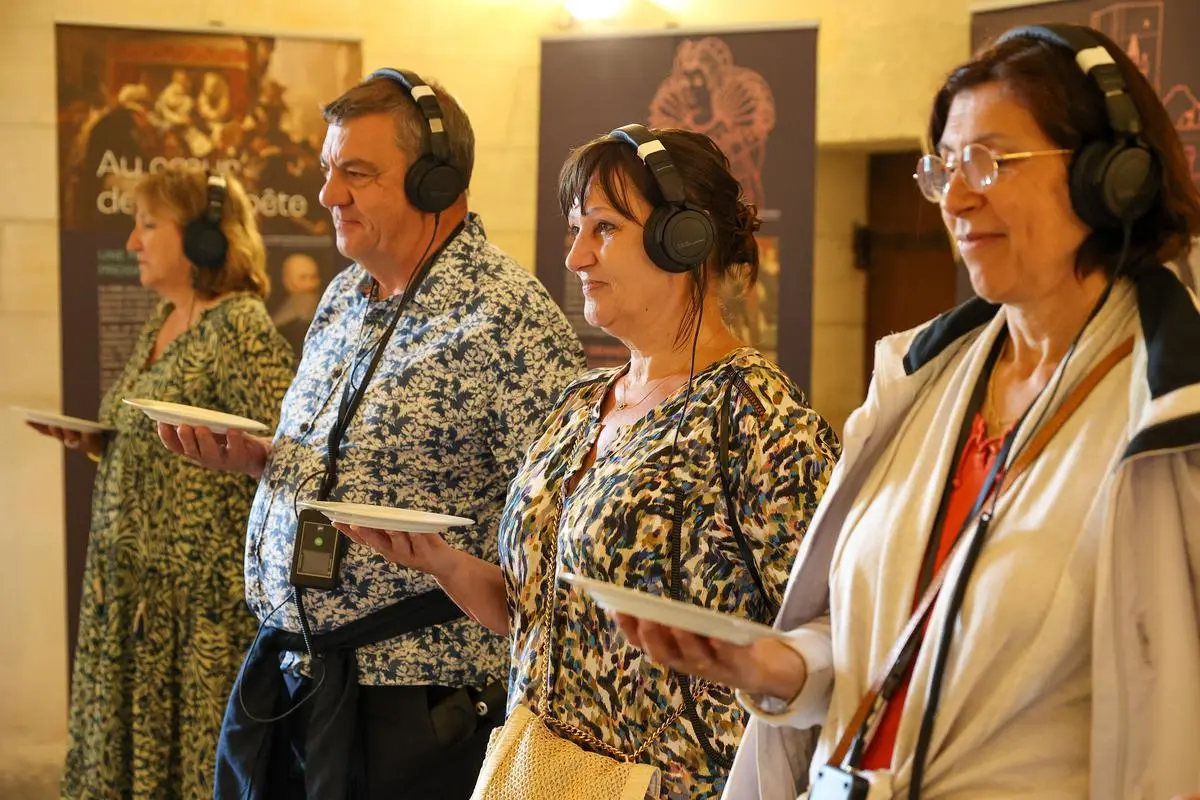 Quatre participants de l'expérience, avec leurs casques, tiennent une assiette à une main